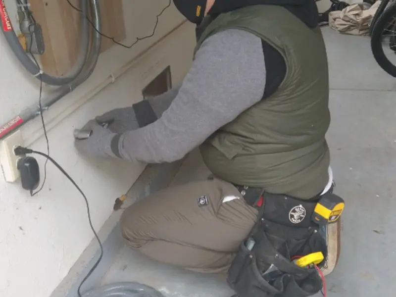 Electrician performing outlet wiring in a Lonsdale garage